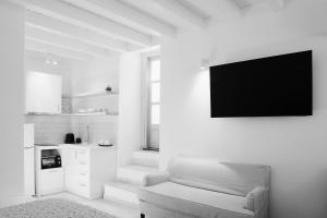 a living room with a couch and a tv on a wall at Galaxidaki στην Πλατεία in Galaxidhion
