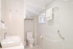 a white bathroom with a sink and a toilet at Galaxidaki στην Πλατεία in Galaxidi +32 photos