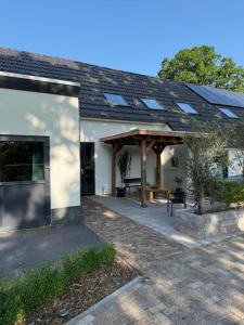 a house with a patio with a roof with solar panels at 't Veurhuus in Ansen