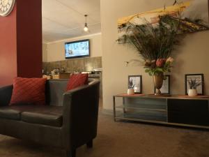 ein Wohnzimmer mit einem Stuhl und einem Tisch mit Blumen in der Unterkunft Vioolsdrift Lodge in Vioolsdrift