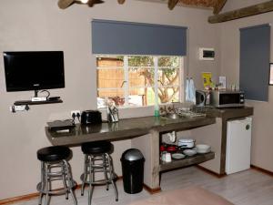 eine Küche mit einer Theke mit Hockern und einer Mikrowelle in der Unterkunft Vioolsdrift Lodge in Vioolsdrift