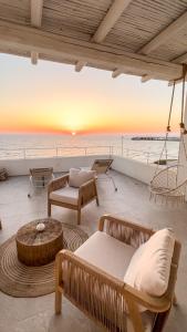 a patio with a view of the ocean at sunset at Palma Residence Salento in San Foca