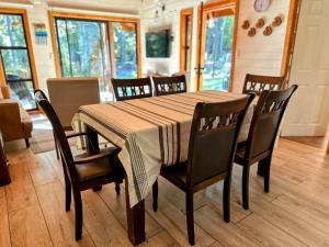 een eettafel met stoelen en een tafelkleed erop bij Cabañas Alto del Bosque in Coñaripe