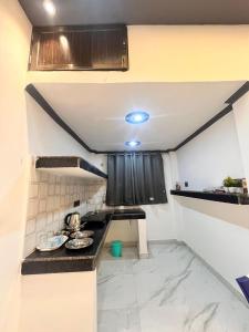 a small kitchen with a counter top in a room at Captains cabin in Tikri Kalān