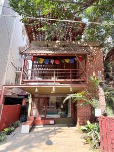 een gebouw met een balkon waaraan vlaggen hangen bij Jugglers Rest Boho Style 4BHK Spacez Luxury Villa with Terrace Lounge in Bangalore