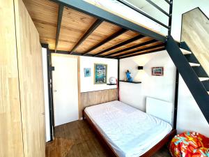 een kleine slaapkamer met een stapelbed en een ladder bij Mezzanines 50 m de la plage in Châtelaillon-Plage