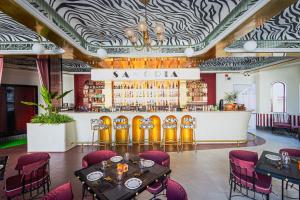 a restaurant with a bar with tables and chairs at Swaroop Vilas - Lake Facing Boutique Hotel in Udaipur