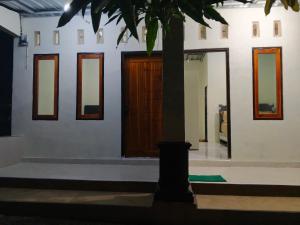 a house with a tree in front of a door at Sherin Homestay in Pulau Sarang
