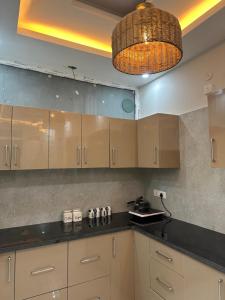 a kitchen with wooden cabinets and a hanging light at Simbas Den by Abodeandco in Dehradun