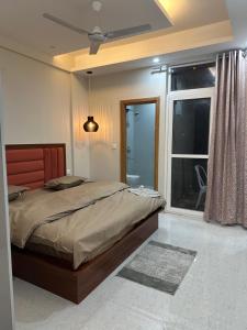 a bedroom with a large bed and a window at Simbas Den by Abodeandco in Dehradun