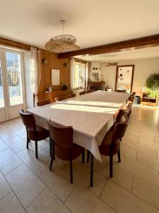een grote eetkamer met een grote tafel en stoelen bij Le Gîte d'Orion in La Bresse