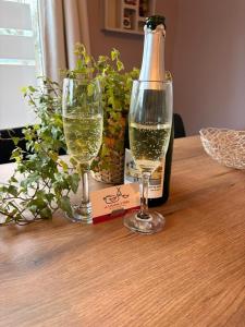 une bouteille de vin et deux verres sur une table dans l'établissement La Louche à Véro, à Ligneuville