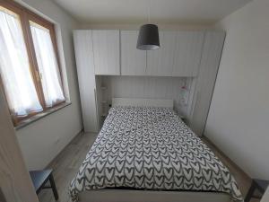 een slaapkamer met een bed met een zwart-wit dekbed bij Cattari House in Marina di Sorso