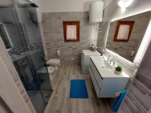 een badkamer met wastafel, douche en toilet bij Cattari House in Marina di Sorso