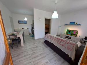 een slaapkamer met een bed en een tafel en een keuken bij Cattari House in Marina di Sorso