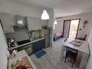 een keuken en een woonkamer met een tafel en een eetkamer bij Cattari House in Marina di Sorso