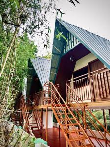 a house with wooden stairs in front of it at Greene Villa in Palakkad