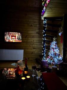 un sapin de Noël dans une pièce avec une table et des verres à vin dans l'établissement Sioni Hillside Cottages, à Sioni