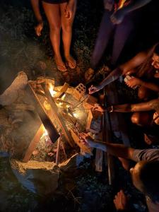 een groep mensen die rond een vuur staan bij FLOR DE ARUANDA - Hostel e Acampamento in Cabo de Santo Agostinho