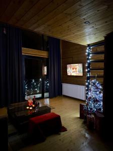 un salon avec un sapin de Noël et une table dans l'établissement Sioni Hillside Cottages, à Sioni