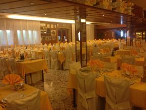 a banquet hall with white tables and white chairs at Hotel Pizzeria Ristorante "Al Leone" in Villa del Conte