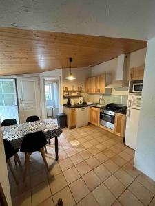 een keuken met een tafel en een keuken met een fornuis en een koelkast bij Maison calme et agréable proche de la mer in Saint-Gervais