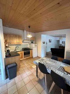 een keuken en een woonkamer met een tafel in een kamer bij Maison calme et agréable proche de la mer in Saint-Gervais