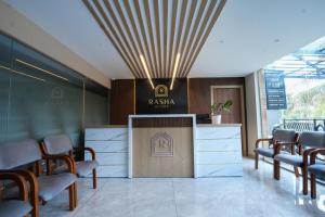 a waiting room with chairs and a counter with a sign at Rasha Suites in Kalpetta