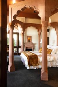 ein großes Schlafzimmer mit zwei Betten und Säulen in der Unterkunft Jodha Bai Retreat in Terranora