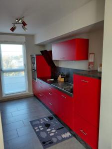 une cuisine rouge avec des placards rouges et une fenêtre dans l'établissement Spacious 3-room penthouse apartment, à Truchtersheim 7 autres photos