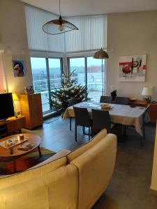 un salon avec un canapé et une table à manger dans l'établissement Spacious 3-room penthouse apartment, à Truchtersheim