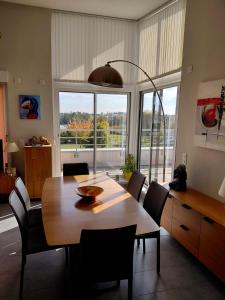 une salle à manger avec une table et des chaises en bois dans l'établissement Spacious 3-room penthouse apartment, à Truchtersheim