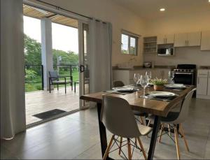 een keuken en eetkamer met een houten tafel en stoelen bij Condominios Akira in Tamarindo