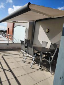une table et des chaises sur le toit d'un bâtiment dans l'établissement Spacious 3-room penthouse apartment, à Truchtersheim