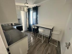 a kitchen with a table and chairs in a room at Garsoniera lux in Craiova +14 photos
