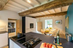 eine Küche mit einer Arbeitsplatte und einem Tisch mit Tomaten in der Unterkunft Renovated Stone House In Normandy in Sourdeval-les-Bois