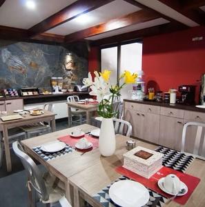 een keuken met een houten tafel en een vaas met bloemen bij Hotel Stella in Talca