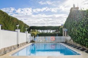 una piscina in un cortile con una recinzione bianca di Alojamientos Nacarum a El Palmar