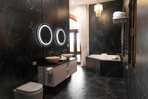 ein Bad mit einem WC, einem Waschbecken und Spiegeln in der Unterkunft Jodha Bai Retreat in Terranora + 52 Fotos