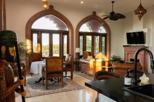 ein Wohnzimmer mit Bogenfenstern und ein Esszimmer in der Unterkunft Jodha Bai Retreat in Terranora