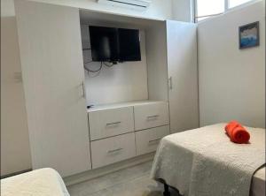 een slaapkamer met een bed en een tv aan de muur bij Condominios Akira in Tamarindo