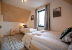 a bedroom with two beds and a window at Domki Tomanova - Premium Chalets in Dzianisz