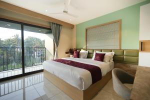 a bedroom with a large bed and a balcony at Rasha Suites in Kalpetta +121 photos