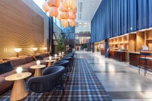 a restaurant with a row of tables and chairs at Scandic Oulu City in Oulu