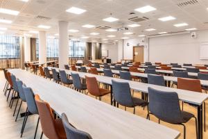 a lecture room with rows of tables and chairs at Scandic Oulu City in Oulu