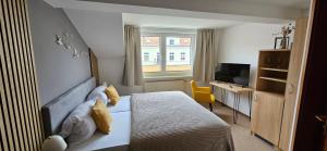 une chambre avec un lit, un bureau et une télévision dans l'établissement Gasthaus Harmonie, à Malchow