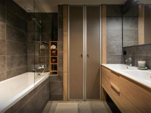 een badkamer met een bad, een wastafel en een douche bij Les Doliges - OVO Network in Les Gets