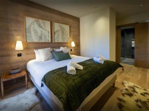 een slaapkamer met een groot bed met handdoeken erop bij Les Doliges - OVO Network in Les Gets