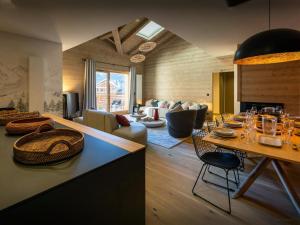 een woonkamer met een tafel met stoelen en een bank bij Les Doliges - OVO Network in Les Gets