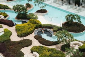 een bovenaanzicht van een zwembad met bomen en struiken bij Hyatt Regency Aqaba Ayla Resort in Aqaba